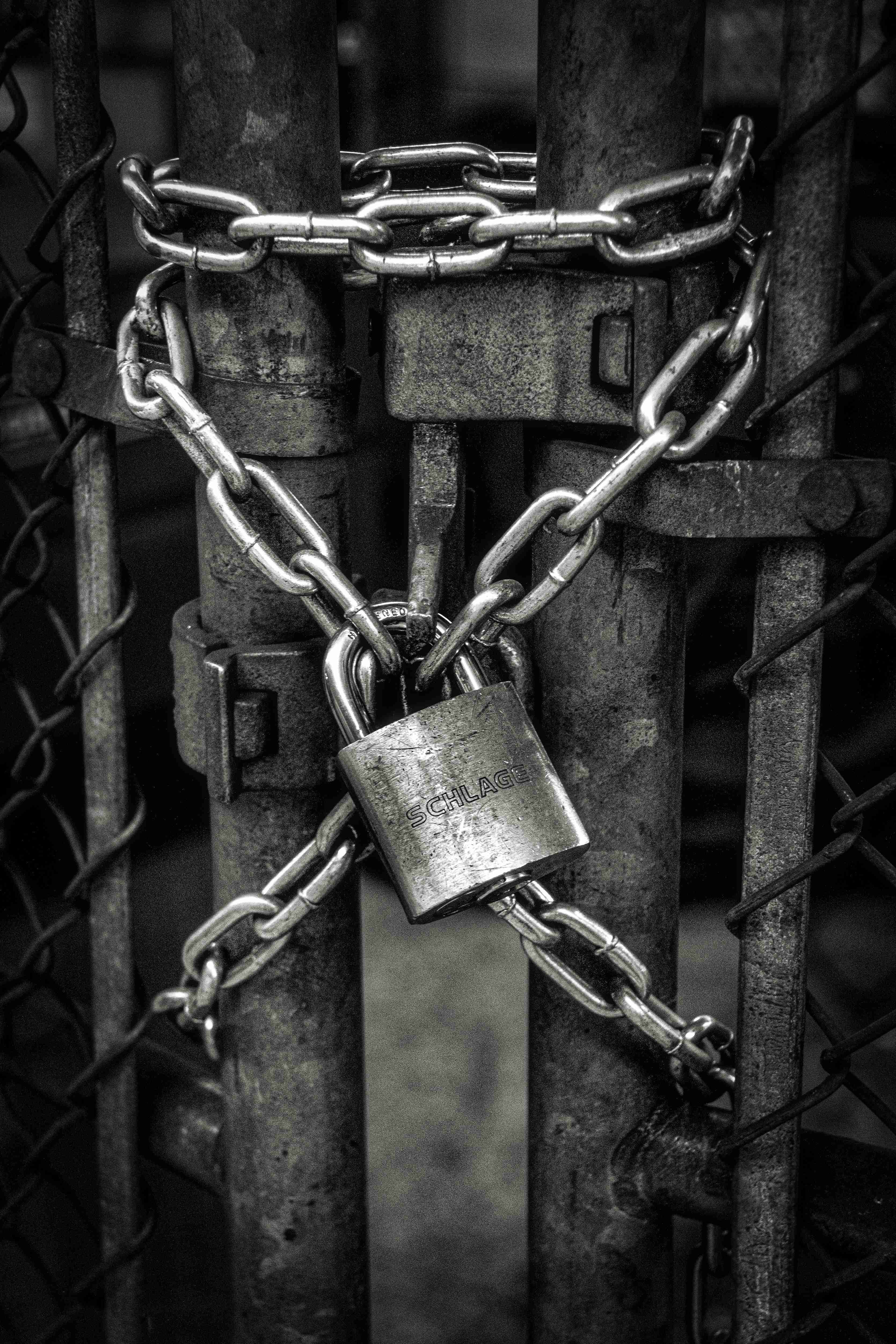 Tightly locked gate with chains and a padlock