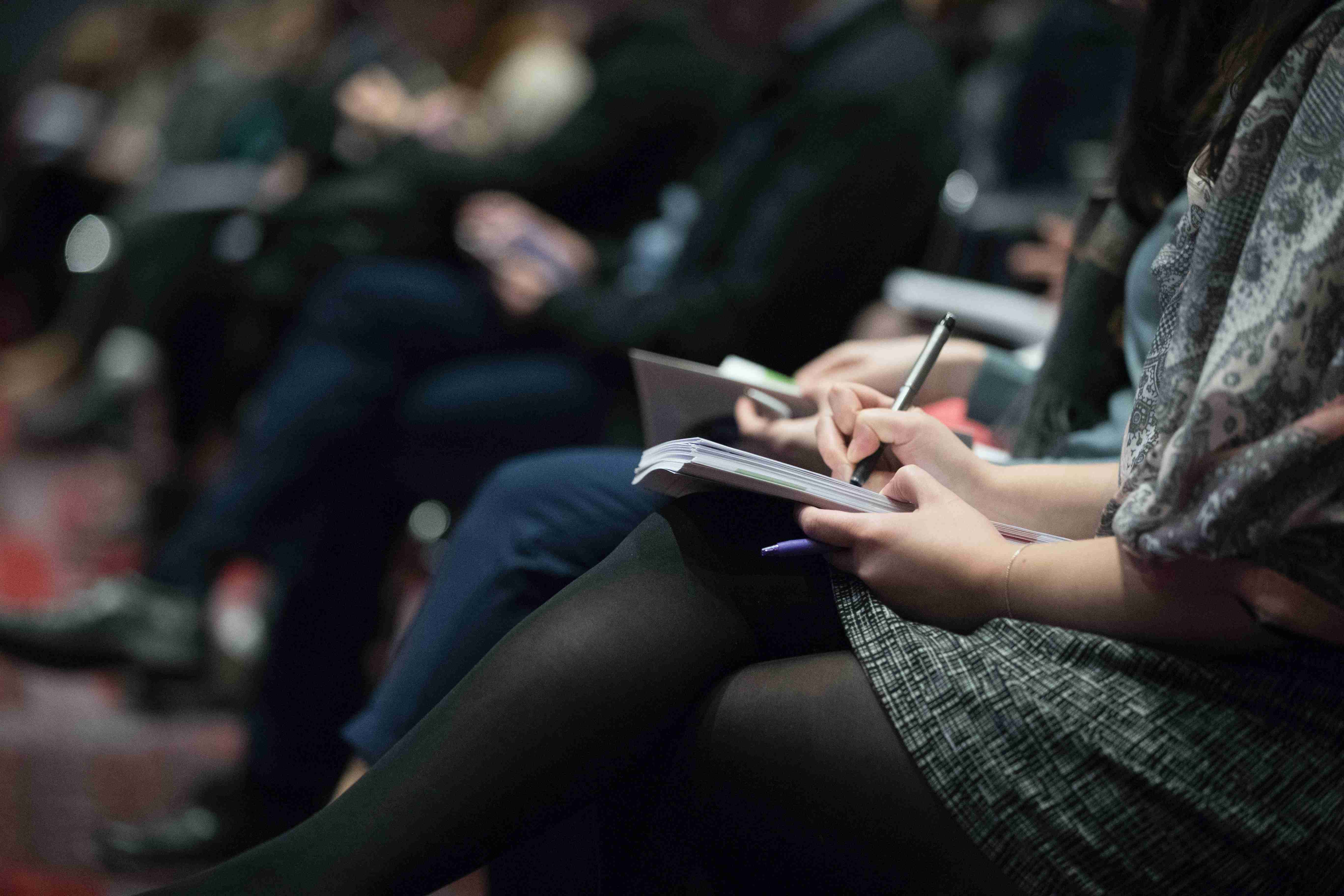 Reporters taking notes at a press conference